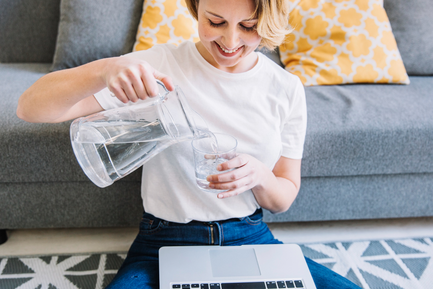 mujer-sonriente-agua-vertiendo-computadora-portatil